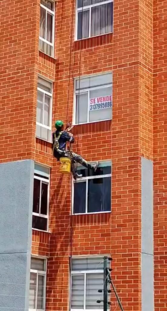 Arreglo de fachadas: Técnico reparando una grieta visible en un muro exterior.